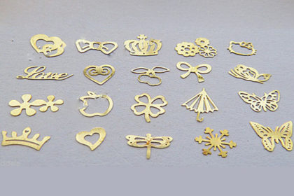 Box mit 100 Stück Goldplättchen in vers. Motiven, 5 x 6 mm